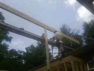 Carpenter setting a ridge beam over a new addition frame — Ice Dam Removal by Roofing Brothers in Kennard