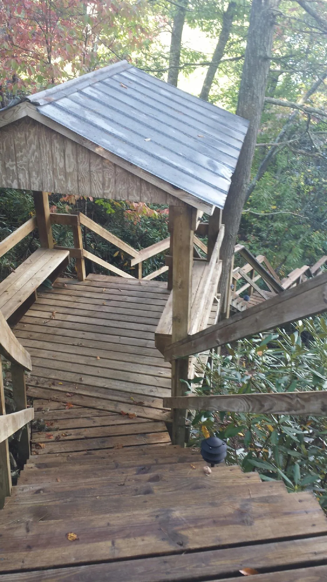 Metal roofed shelter over wooden steps on a wooded walkway — Skylight Repair & Installation work by our crew in Kennard